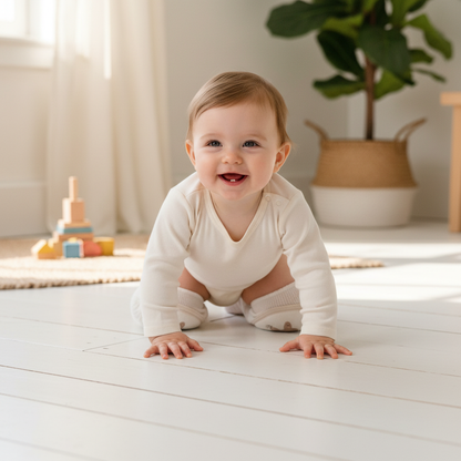 Baby wearing TROPELA knee pads while crawling on wooden floor